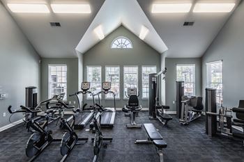 A gym with exercise equipment and windows on the wall